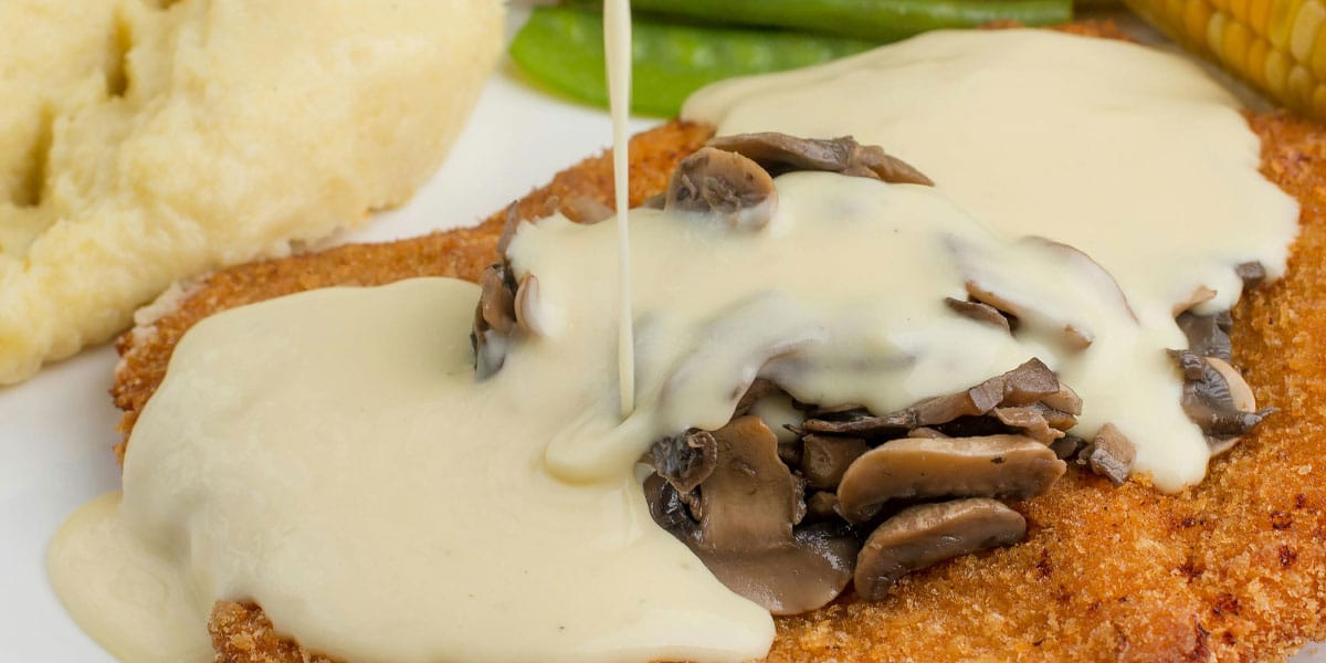 Ocvrt zrezek z gobovo smetanovo omako in krompirjevim pirejem